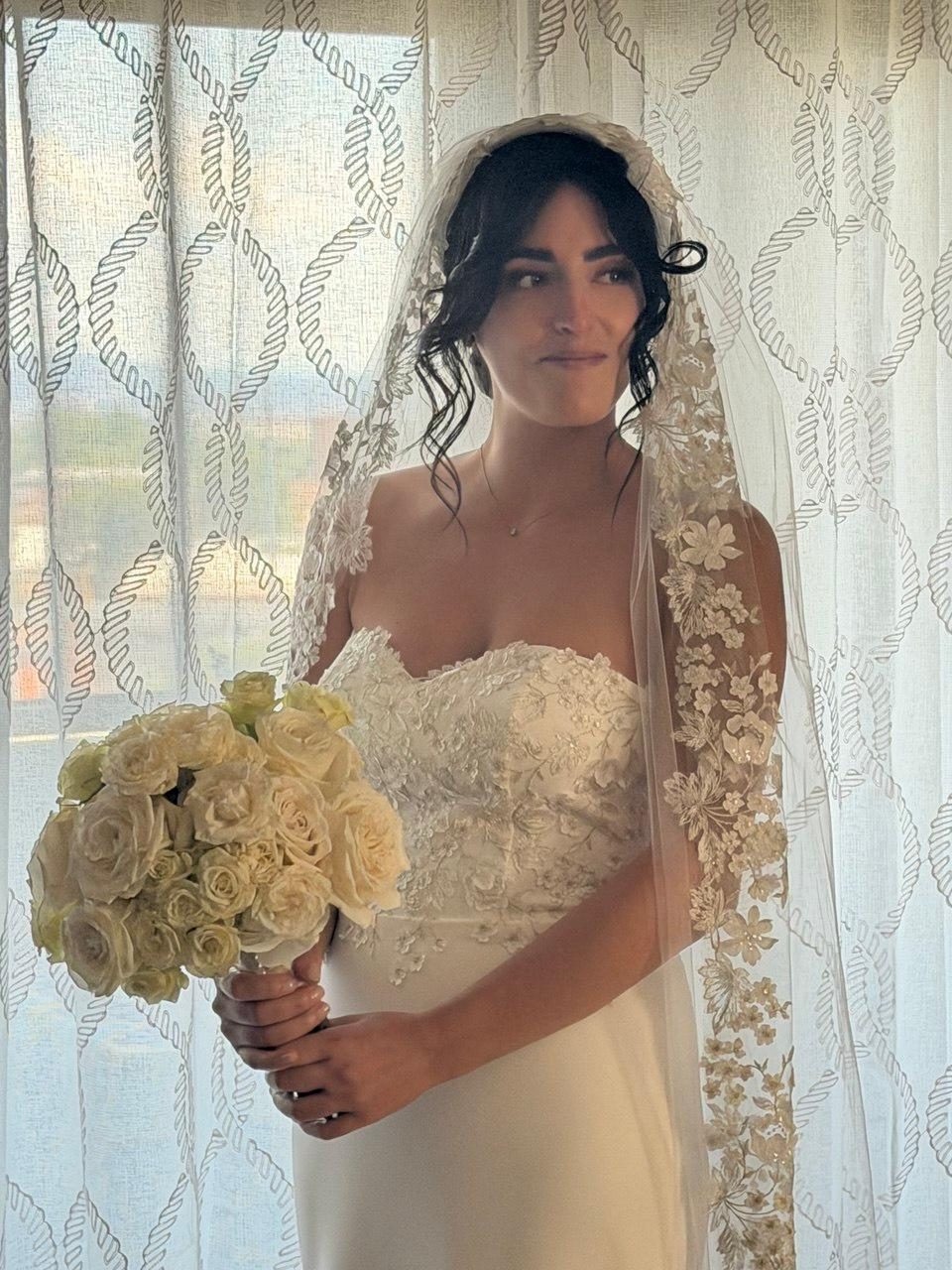 Sposa con velo in pizzo e bouquet