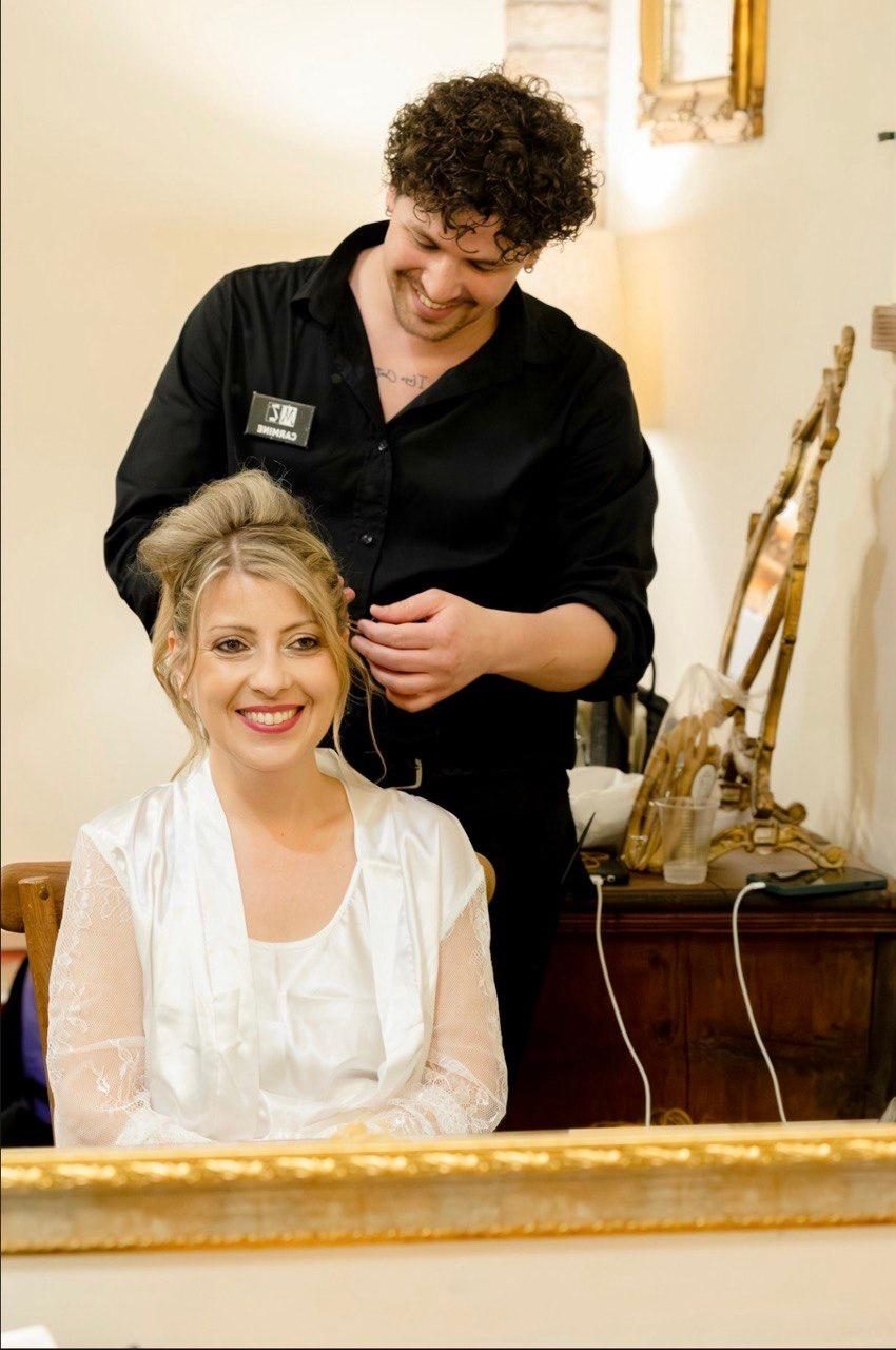 Lo stylist rifinisce l'acconciatura della sposa